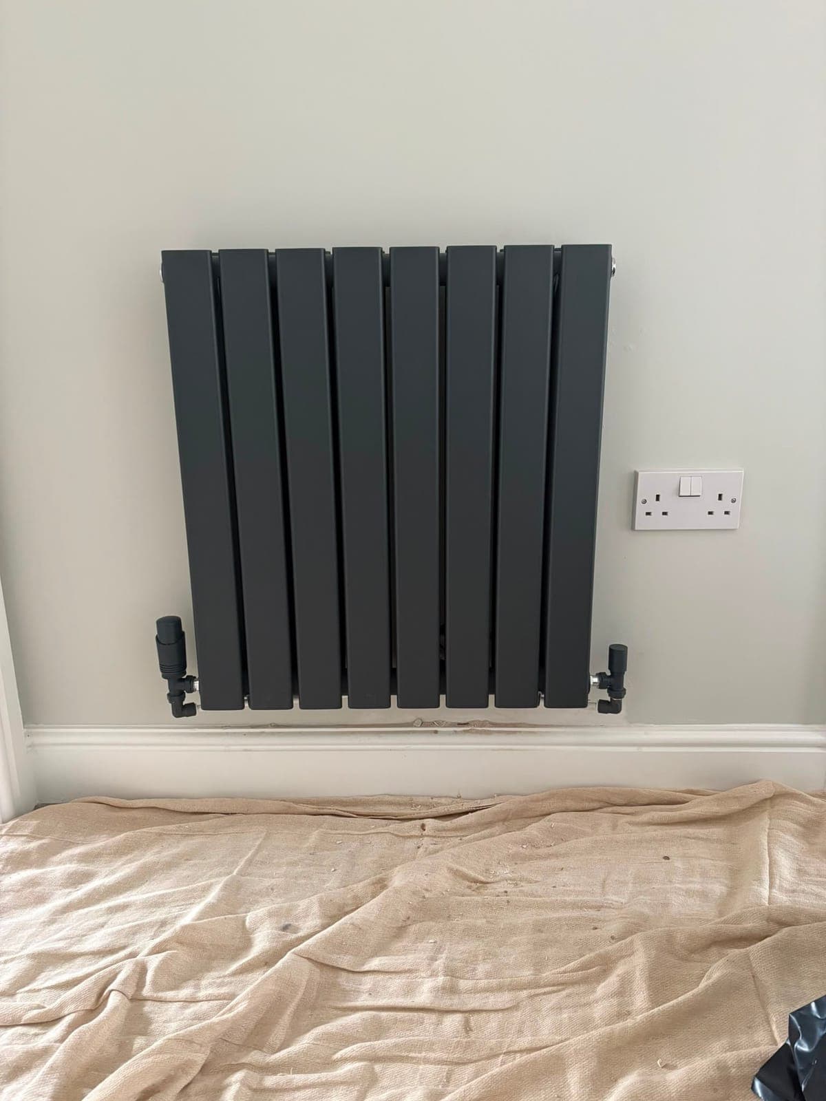 Anthracite designer panel radiator fitted on a wall